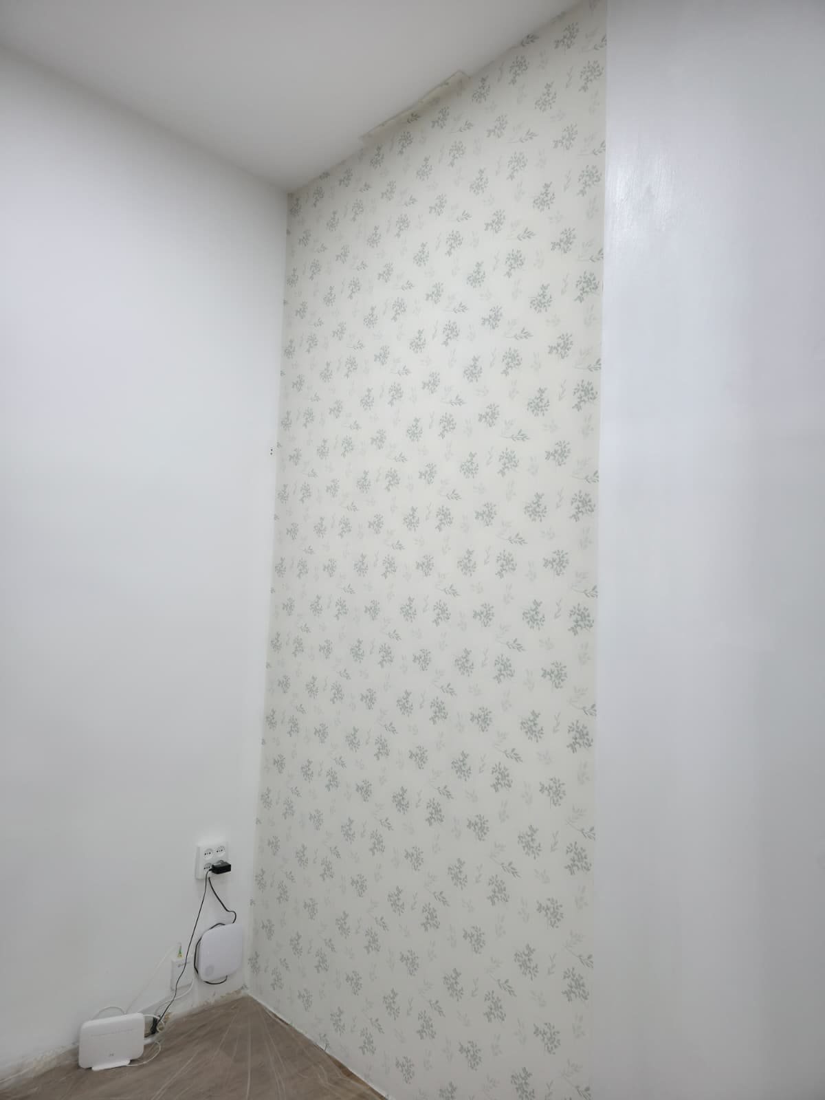 Pared terminada con papel pintado de motivo floral, sin juntas visibles en la esquina