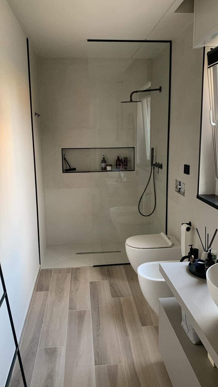 Ducha a ras de suelo con hornacina empotrada y grifería negra mate sobre azulejo claro